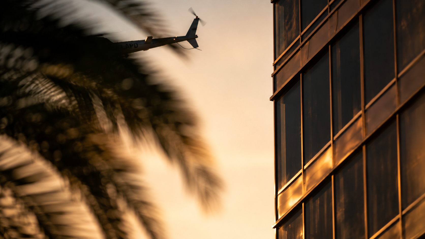 Helicopter passing reflective architecture in Los Angeles